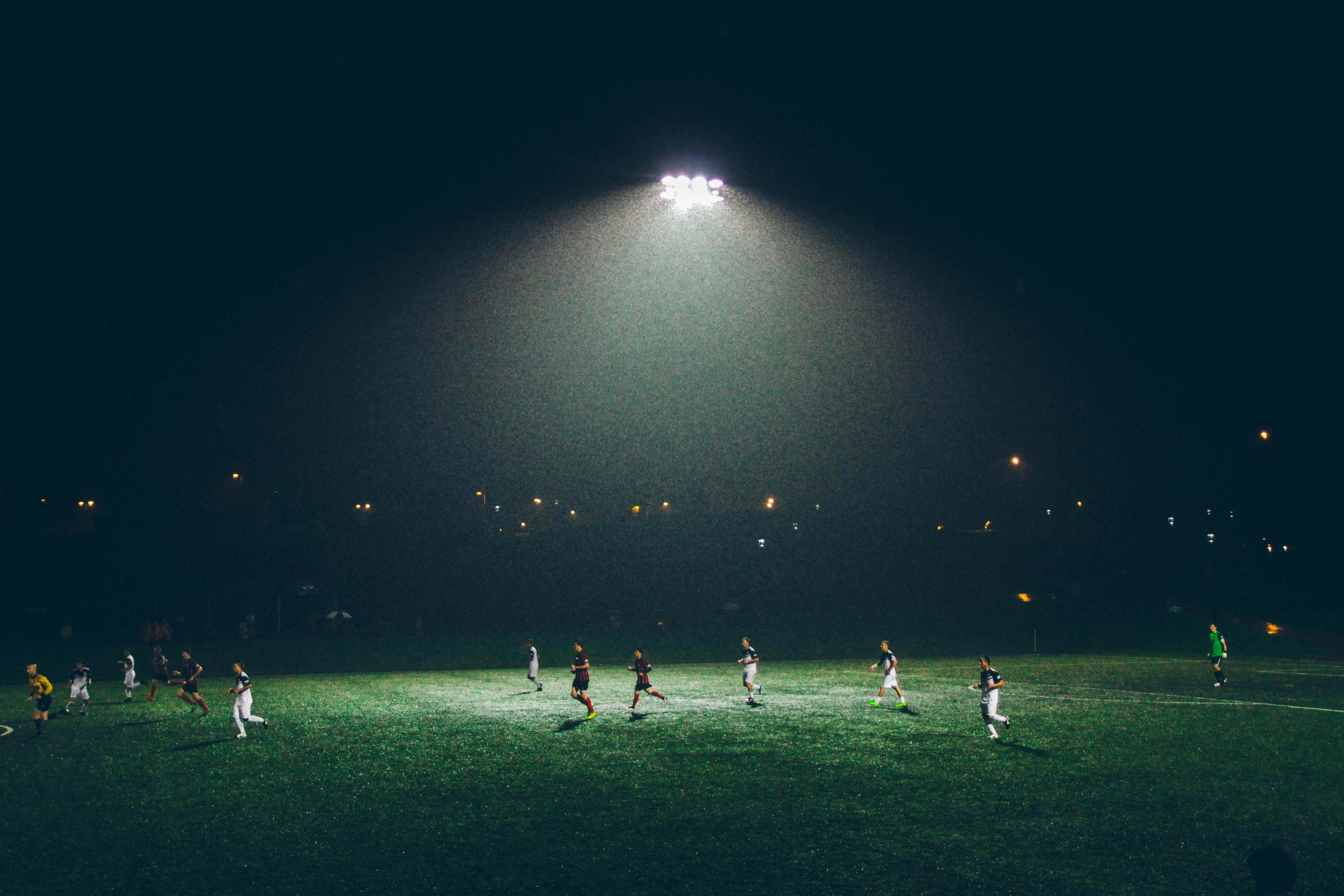 Soccer match under stadium lights with fans in the stands